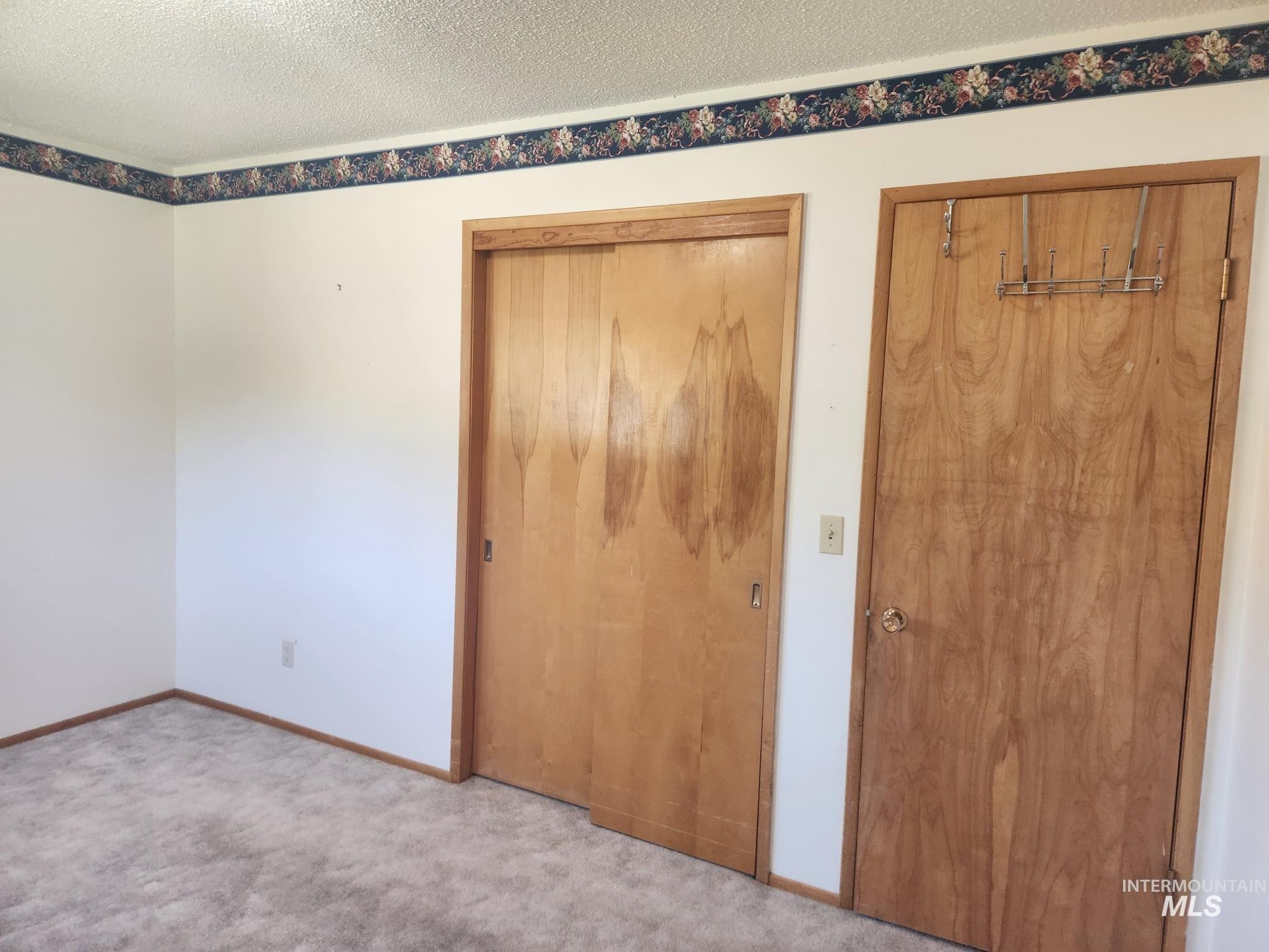 367 Woodland Road Kamiah, ID 83536 - Photo 17 of 45 Unfurnished bedroom with a textured ceiling, carpet flooring, and multiple closets