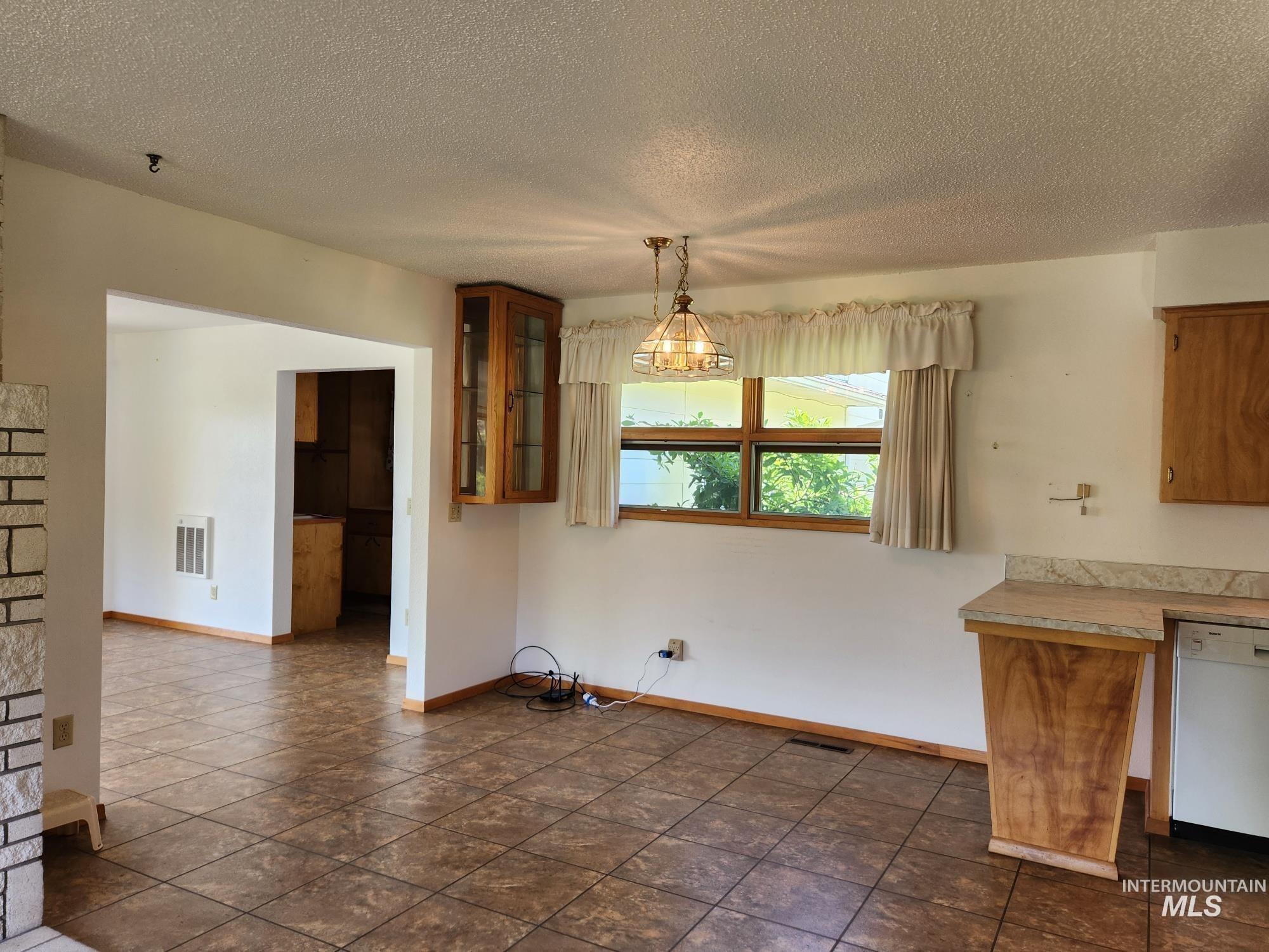 367 Woodland Road Kamiah, ID 83536 - Photo 9 of 45 Unfurnished dining area featuring baseboards and a textured ceiling
