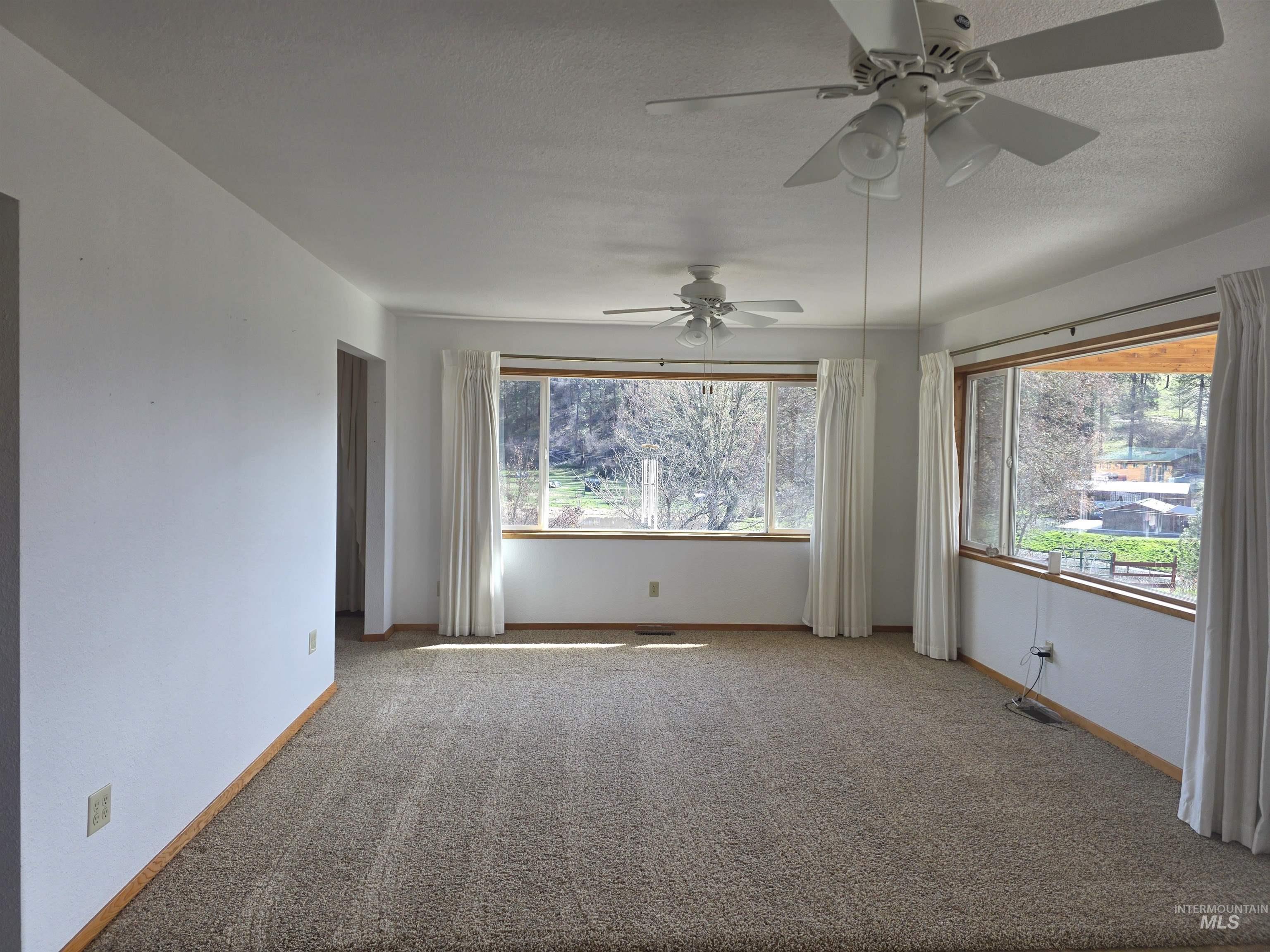 367 Woodland Road Kamiah, ID 83536 - Photo 10 of 45 Carpeted empty room featuring plenty of natural light, a textured ceiling, and ceiling fan