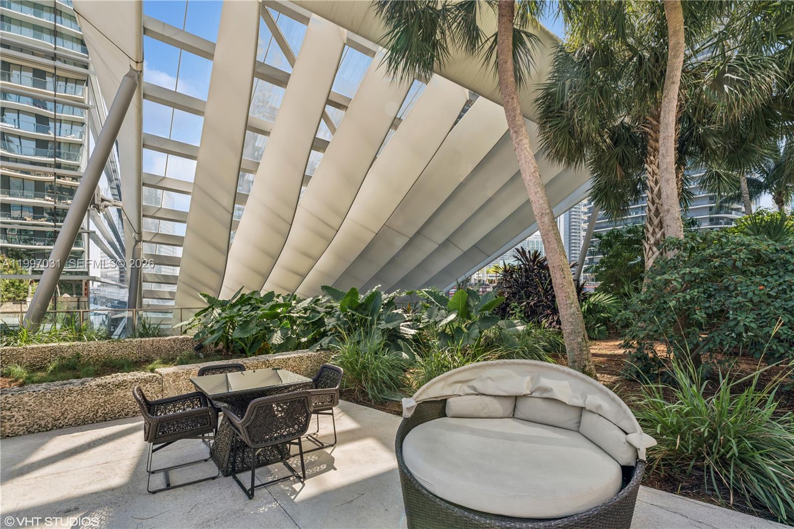 88 Southwest 7th Street, Unit 1804 Miami, FL 33130 - Photo 12 of 39 a backyard of a house with table and chairs