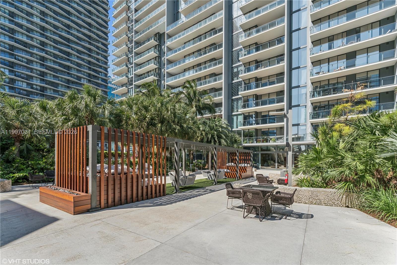 88 Southwest 7th Street, Unit 1804 Miami, FL 33130 - Photo 10 of 39 a view of a patio with a table and chairs and potted plants
