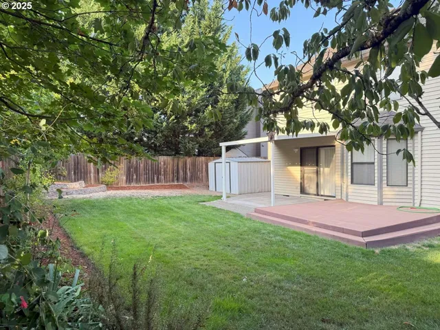 a view of a backyard with table and chairs and wooden fence