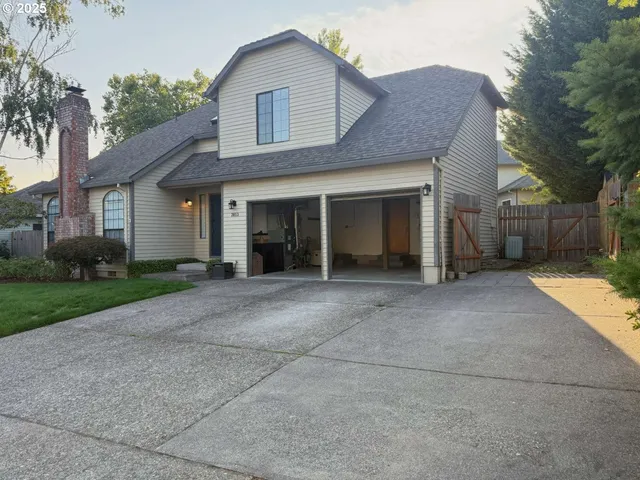a view of a house with a yard and large tree