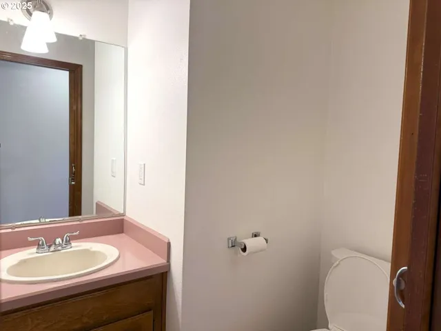 a bathroom with a granite countertop sink toilet and a mirror