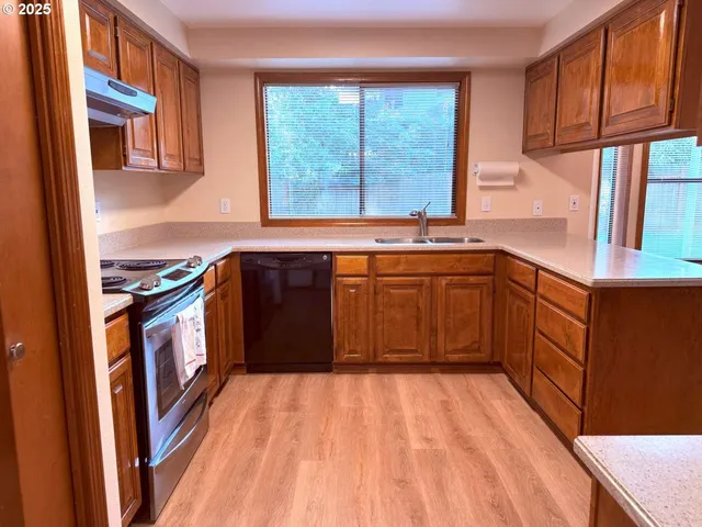 a kitchen with stainless steel appliances granite countertop a stove a sink dishwasher and a refrigerator