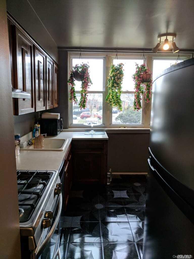 258-16 149th Road Queens, NY 11422 - Photo 5 of 11 a kitchen with a large window and cabinets