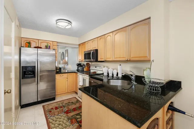 a kitchen with granite countertop a refrigerator a stove and a sink