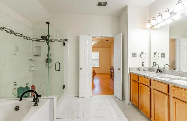 a bathroom with a granite countertop sink a mirror a shower and a bathtub