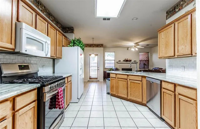 a kitchen with stainless steel appliances granite countertop a stove a sink and a refrigerator