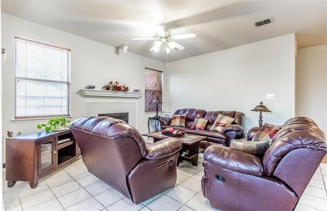 a living room with furniture a fireplace and a window