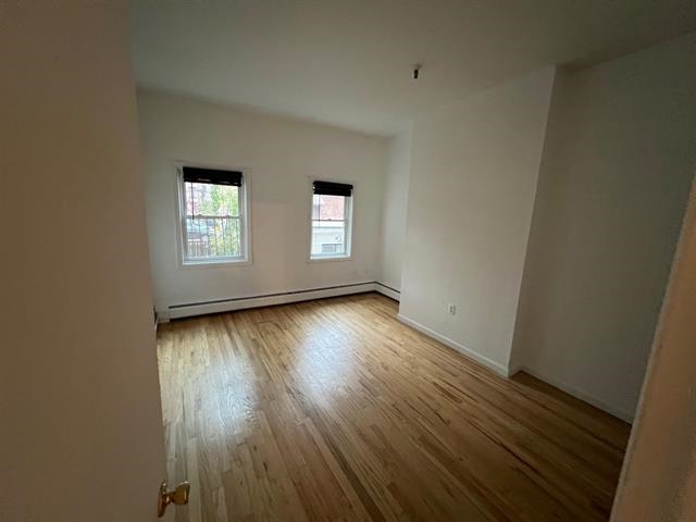 58 Madison Street, Unit 2 Hoboken, NJ 07030 - Photo 14 of 28 an empty room with wooden floor and windows