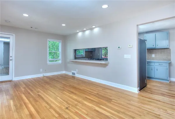 a view of a kitchen with wooden floor and natural light