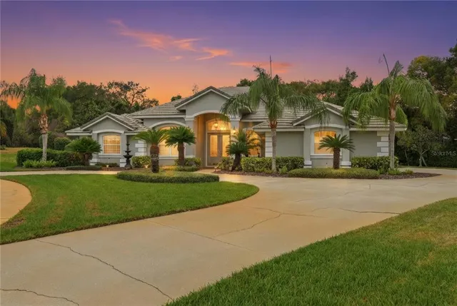 a front view of a house with a yard and trees