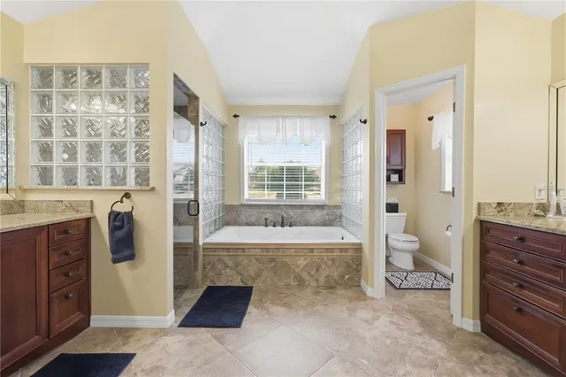 a spacious bathroom with a tub sink and mirror