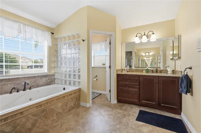 a spacious bathroom with a tub sink shower and mirror