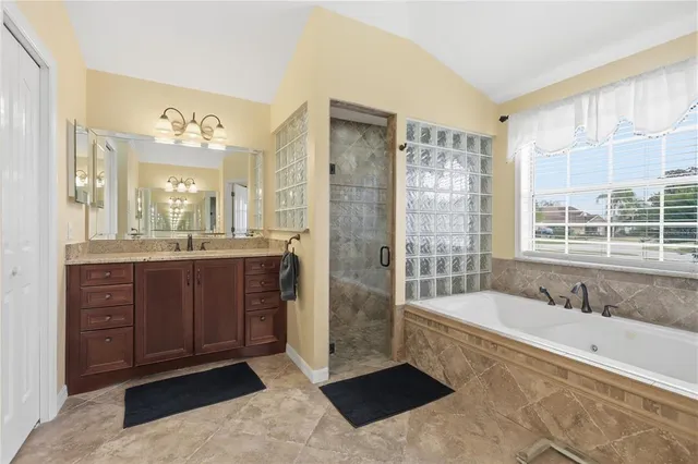 a spacious bathroom with a tub sink shower and a mirror