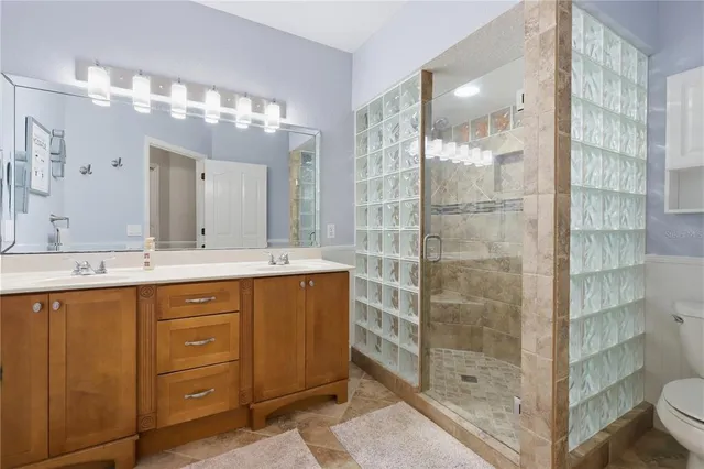a bathroom with a double vanity sink mirror and shower