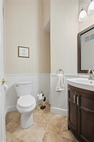 a bathroom with a toilet a sink and mirror