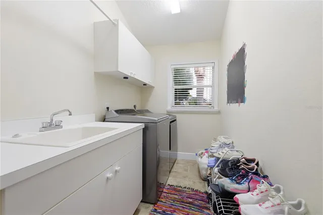 a utility room with cabinets washer and dryer
