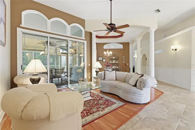 a living room with furniture a large window and a chandelier