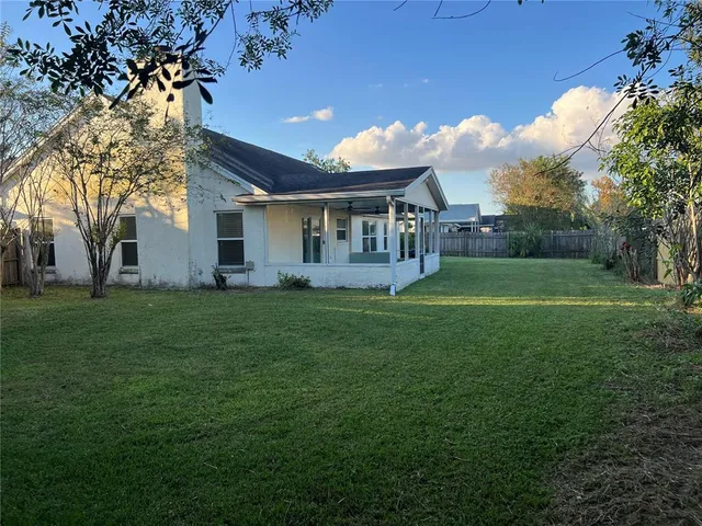 a view of a house with backyard and trees