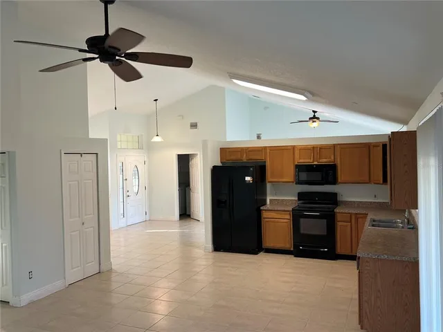 a kitchen with granite countertop a refrigerator stove top oven and sink