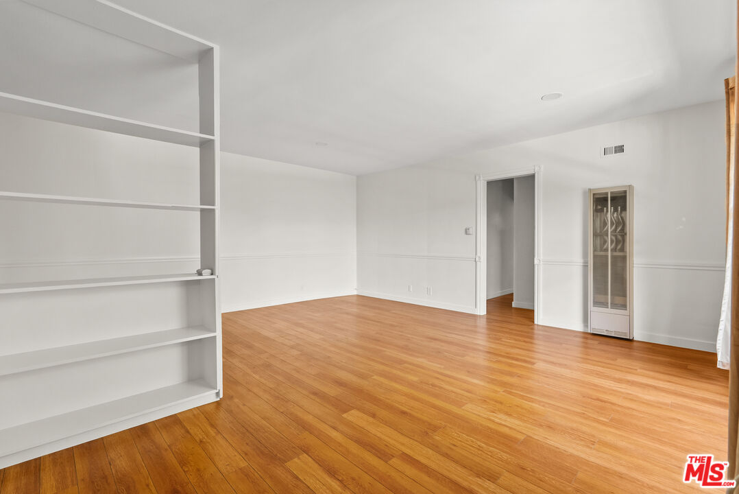 272 South Doheny Drive, Unit 1 Beverly Hills, CA 90211 - Photo 15 of 44 a view of an empty room with wooden floor and a window
