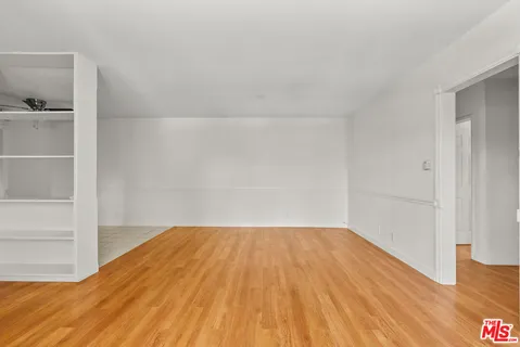 a view of empty room with wooden floor