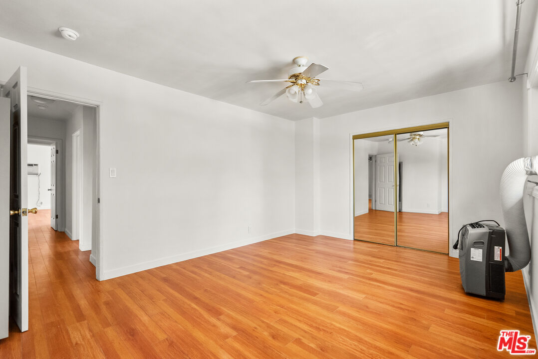 272 South Doheny Drive, Unit 1 Beverly Hills, CA 90211 - Photo 26 of 44 a bedroom with a bed and wooden floor