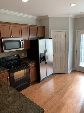 a kitchen with granite countertop stainless steel appliances and wooden cabinets