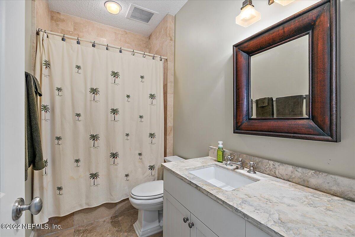 3425 Lands End Drive St. Augustine, FL 32084 - Photo 60 of 79 a bathroom with a granite countertop sink toilet and shower
