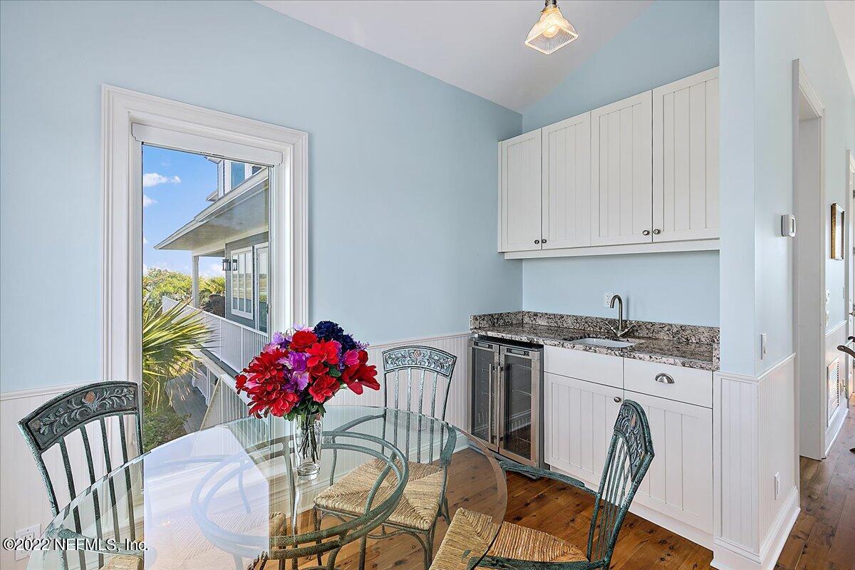 3425 Lands End Drive St. Augustine, FL 32084 - Photo 70 of 79 a kitchen with stainless steel appliances granite countertop a stove top oven a dining table and chairs with wooden floor