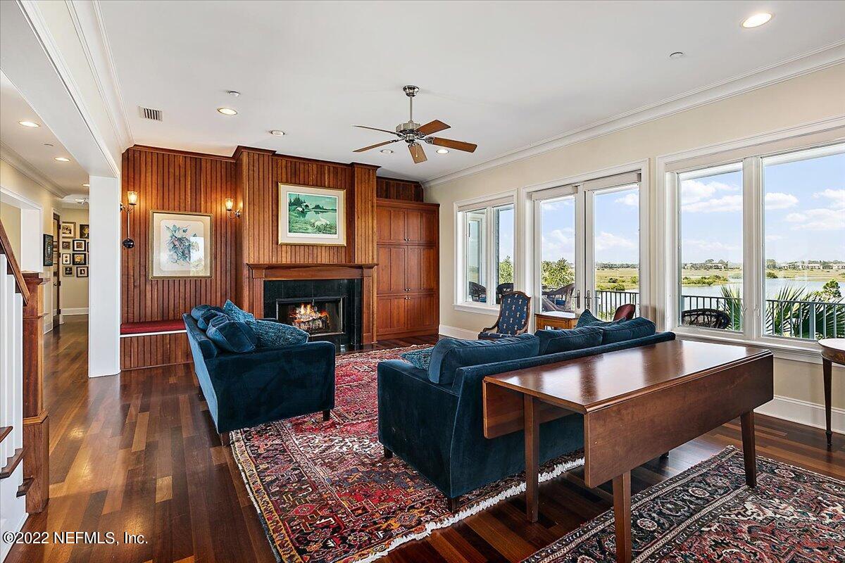 3425 Lands End Drive St. Augustine, FL 32084 - Photo 7 of 79 a living room with furniture a fireplace and a floor to ceiling window