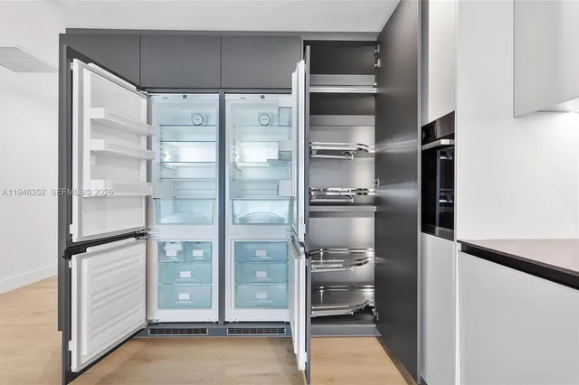 a kitchen with a refrigerator and a glass door