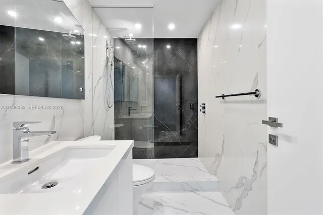 a bathroom with a sink a toilet and shower