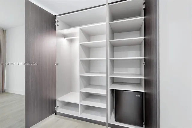 a view of walk in closet with empty racks