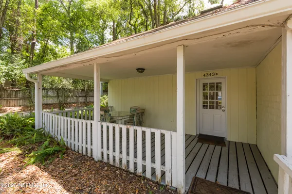 a view of a porch with wooden floor and floor to ceiling window