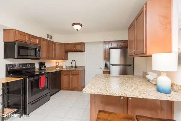a kitchen with stainless steel appliances granite countertop a sink stove and refrigerator