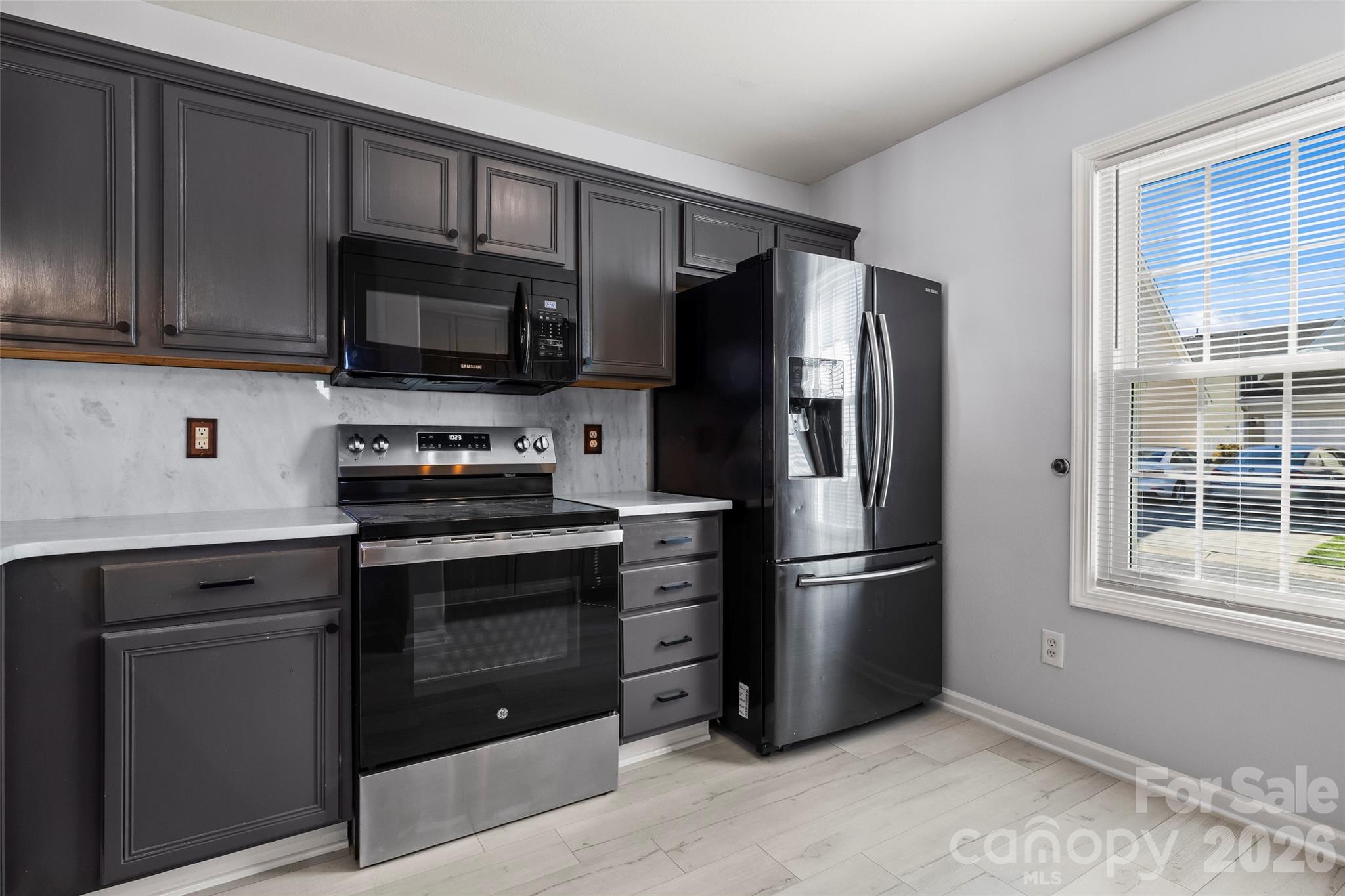4485 Easywater Lane Fort Mill, SC 29707 - Photo 8 of 29 a kitchen with stainless steel appliances granite countertop a refrigerator stove and microwave