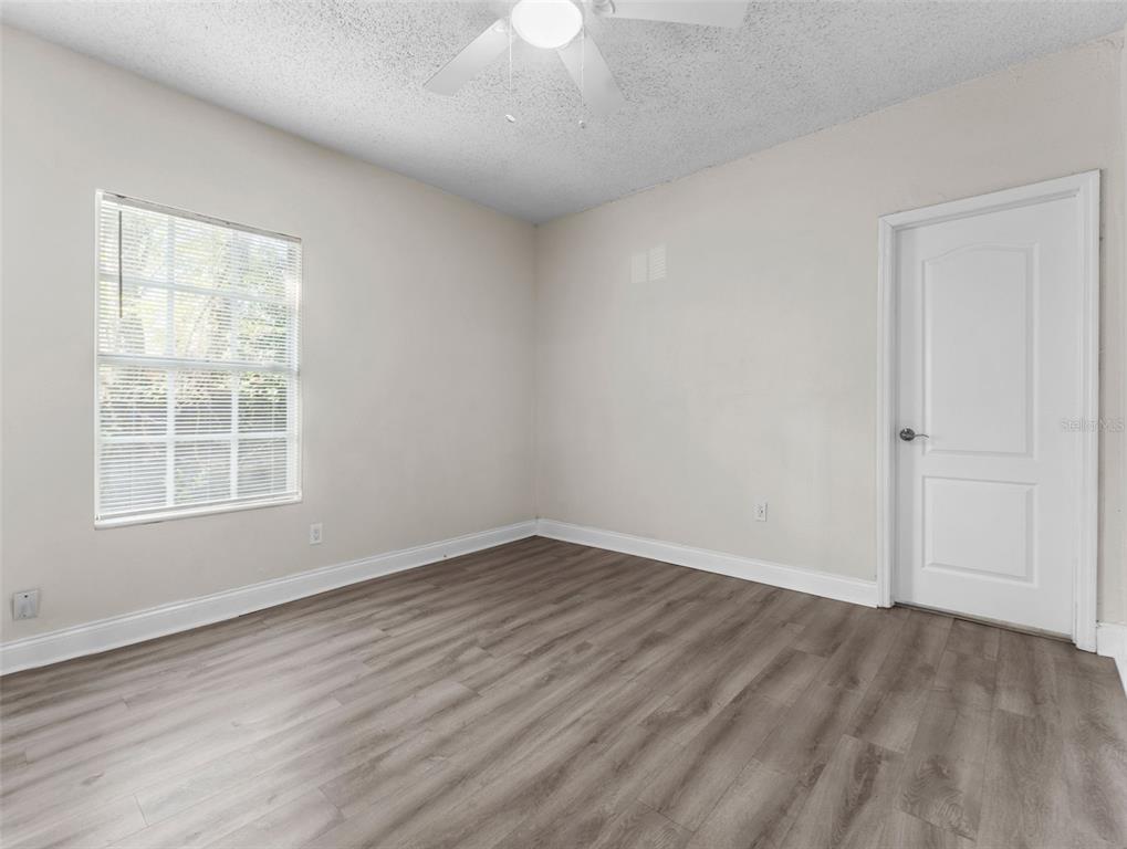 8210 North Klondyke Street, Unit 1 Tampa, FL 33604 - Photo 11 of 34 an empty room with wooden floor cabinet and windows