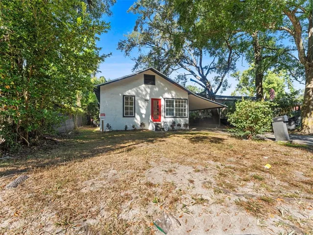 a front view of house with yard and trees around