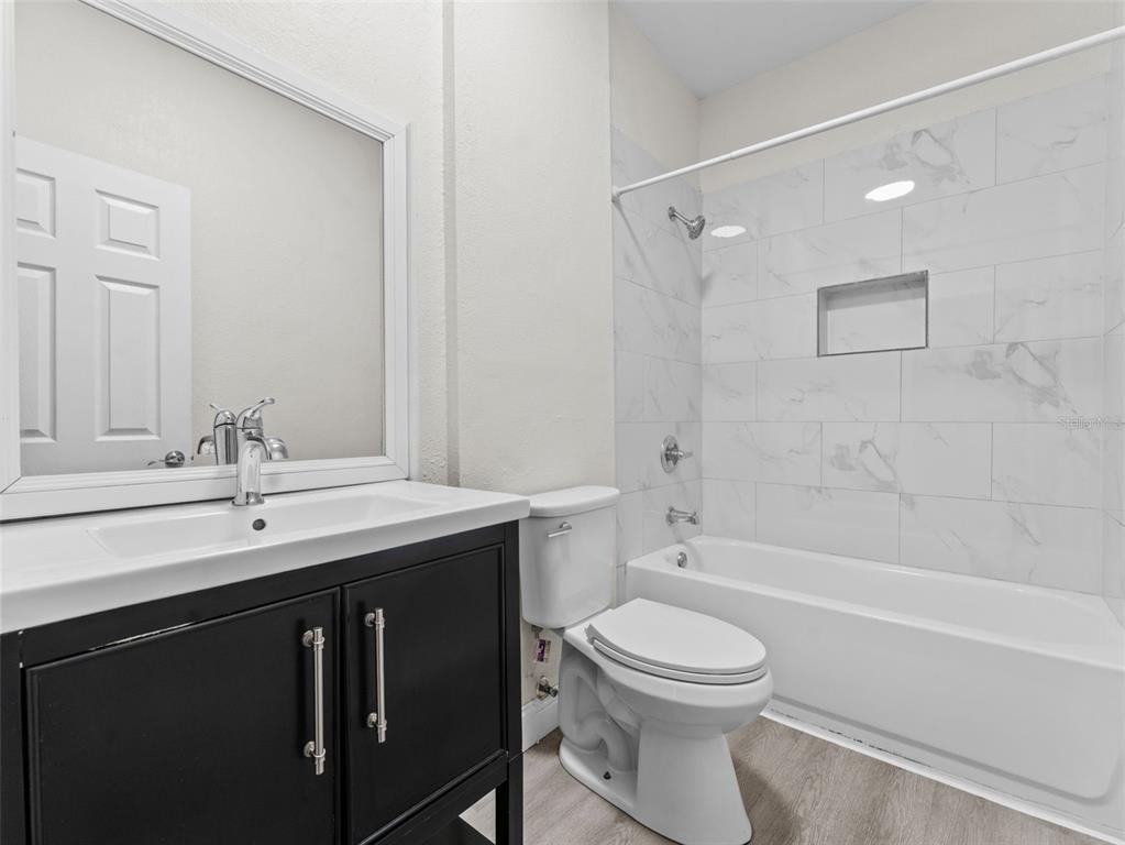 8210 North Klondyke Street, Unit 1 Tampa, FL 33604 - Photo 23 of 34 a bathroom with a toilet a sink a mirror and a bathtub