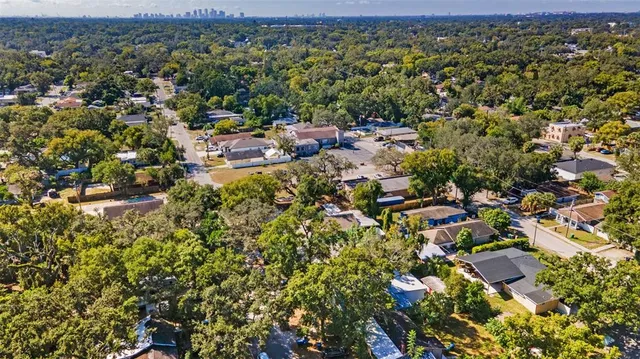 an aerial view of residential houses with outdoor space and trees