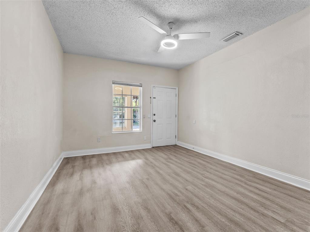 8210 North Klondyke Street, Unit 1 Tampa, FL 33604 - Photo 6 of 34 a view of an empty room with wooden floor and a window