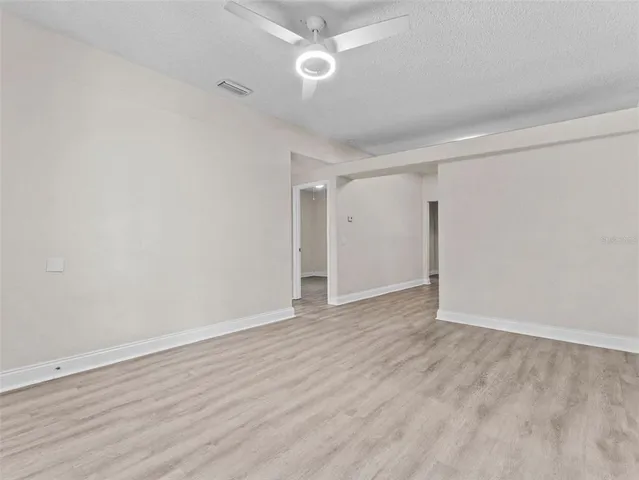 a view of an empty room with wooden floor