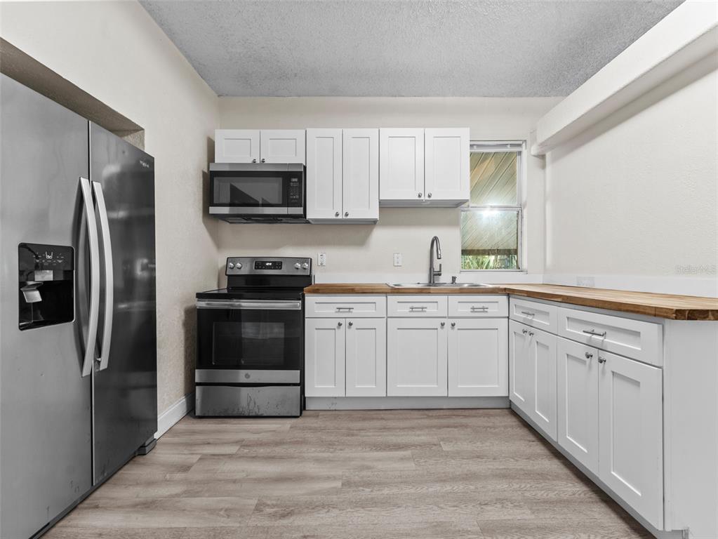 8210 North Klondyke Street, Unit 1 Tampa, FL 33604 - Photo 9 of 34 a kitchen with granite countertop a refrigerator stove and microwave