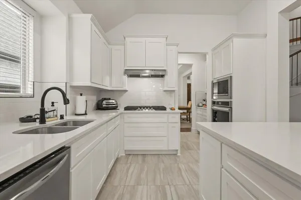a kitchen with a sink stainless steel appliances and cabinets