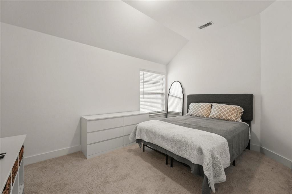 1714 Highwood Road Forney, TX 75126 - Photo 15 of 28 Bedroom featuring light colored carpet and vaulted ceiling