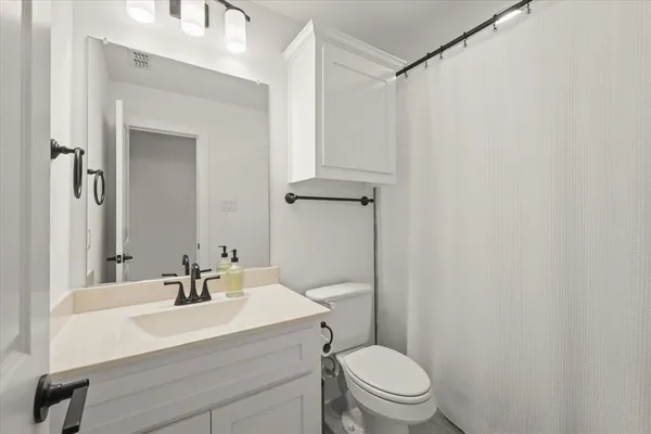 a bathroom with a sink a toilet a mirror and shower