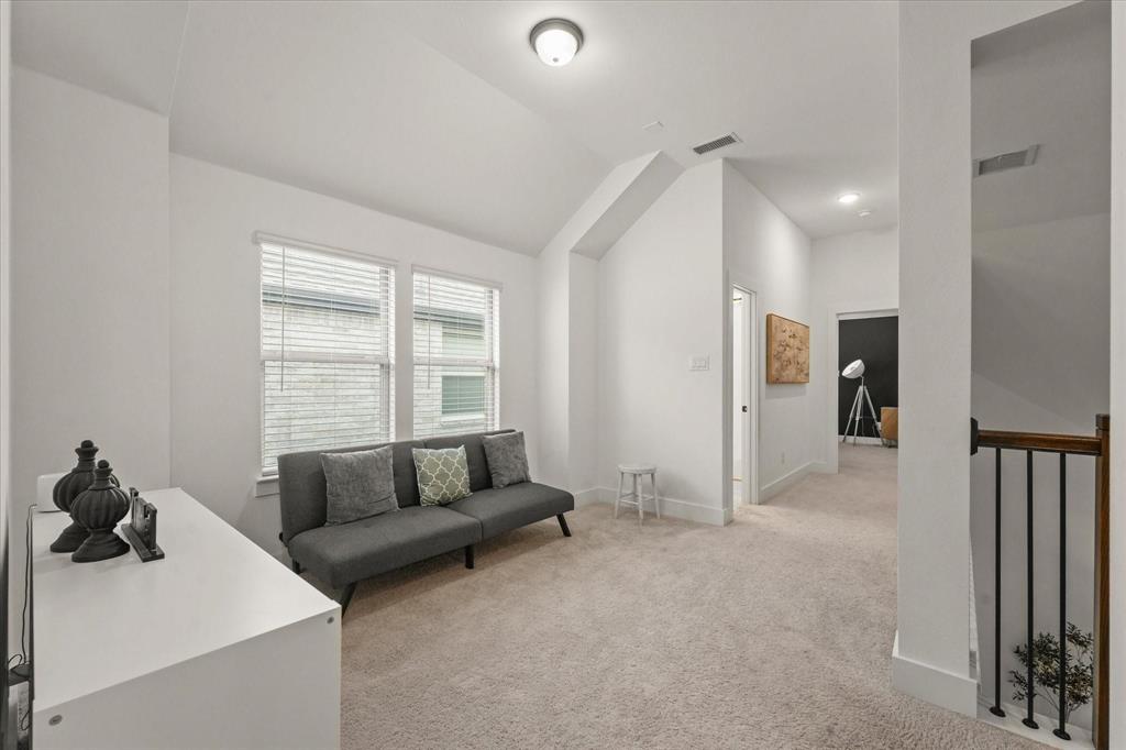 1714 Highwood Road Forney, TX 75126 - Photo 18 of 28 Living area featuring light carpet, vaulted ceiling, and an upstairs landing